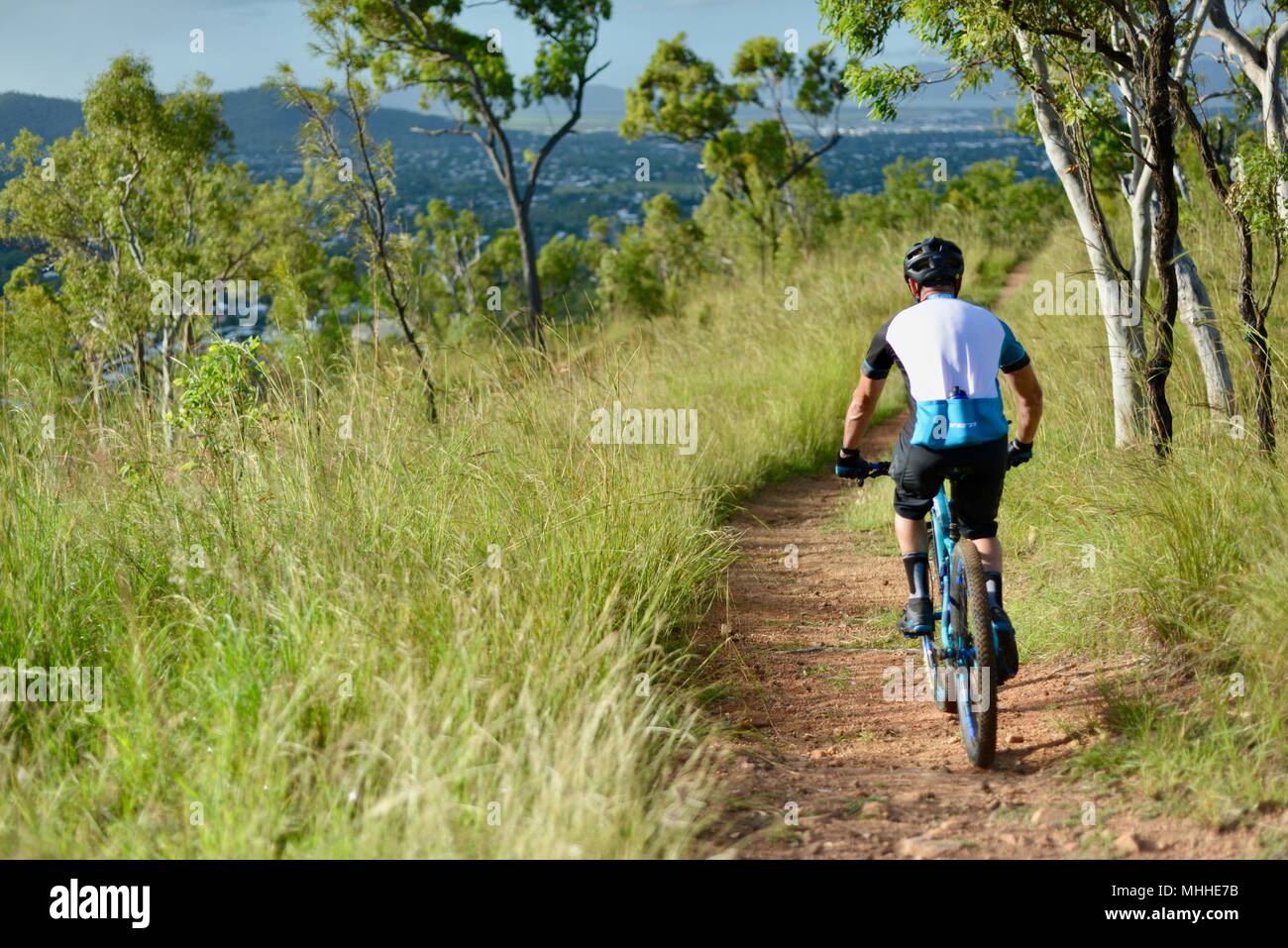 Male bicycle rider on a mountain bike going down a hill on a gravel