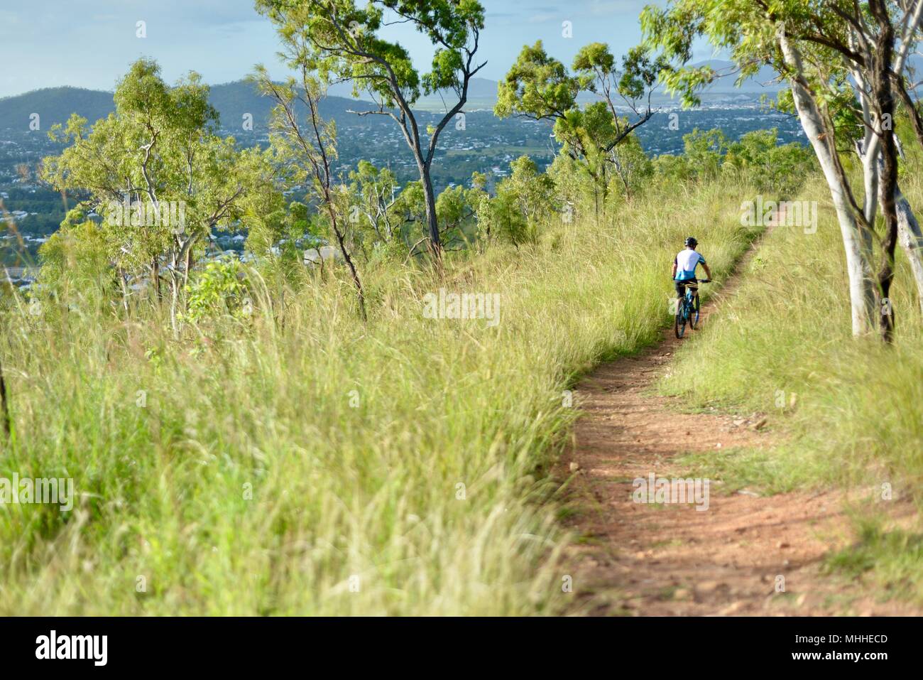 Male bicycle rider on a mountain bike going down a hill on a gravel