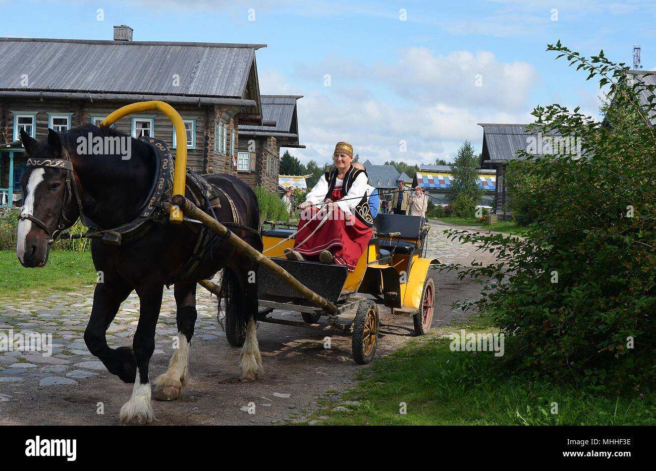 TRADITIONAL HORSE AND CART CONVEYING TOURISTS. MANDROGI, RUSSIA Stock Photo