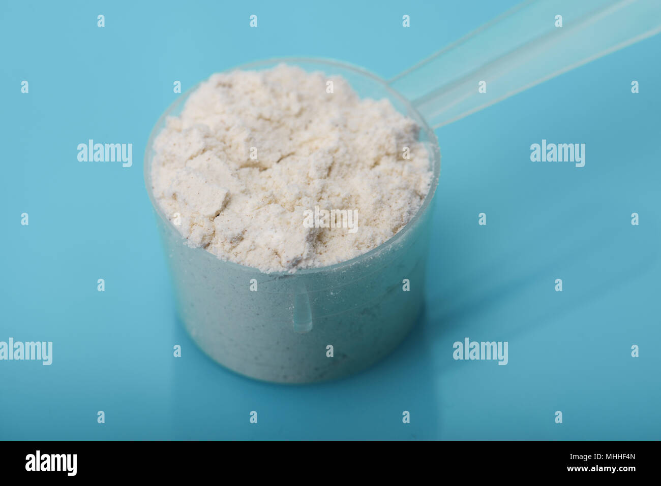 Creatine monohydrate in scoop on creatine monohydrate background with