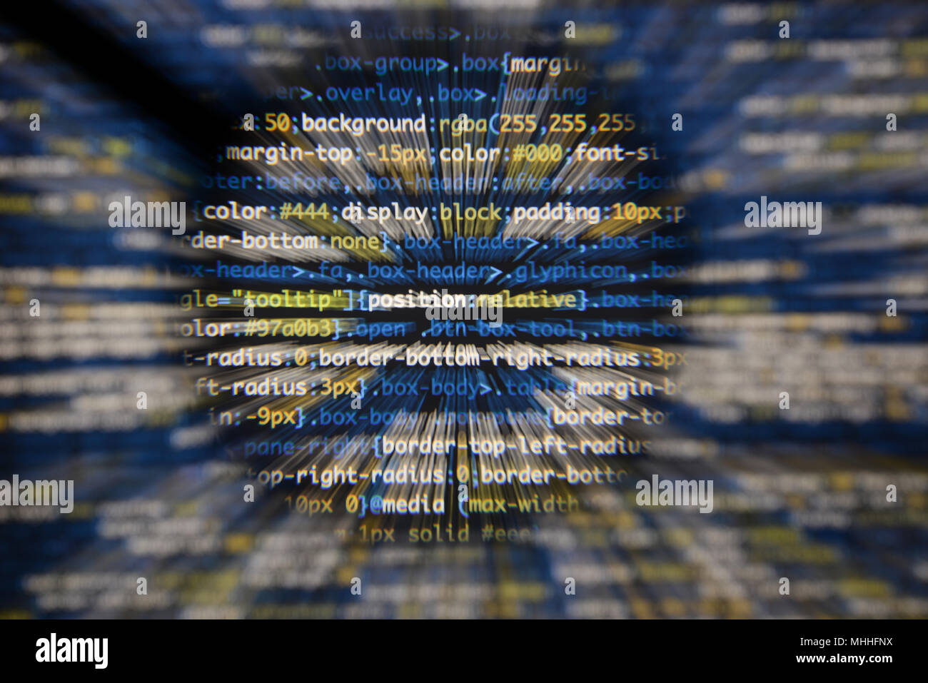 Real css code developing screen. Programing workflow abstract algorithm concept. Lines of css code visible under magnifying lens with moviment effect. Stock Photo