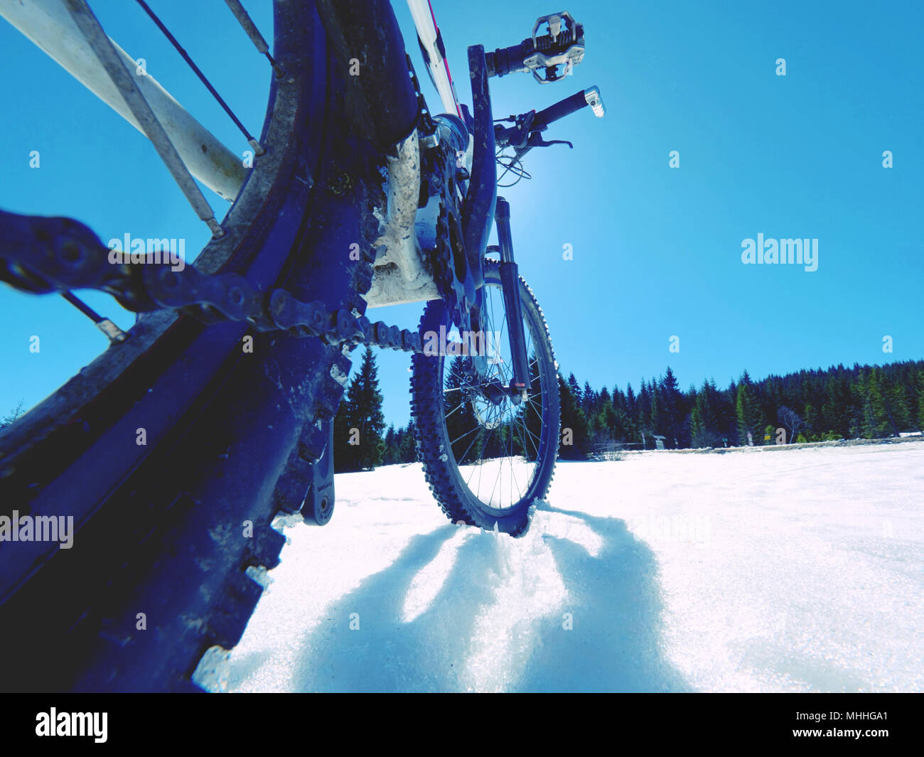 Mountain bike in snow. Cycling on large tire wheels in fresh snow. Cyclist goes on bike on the