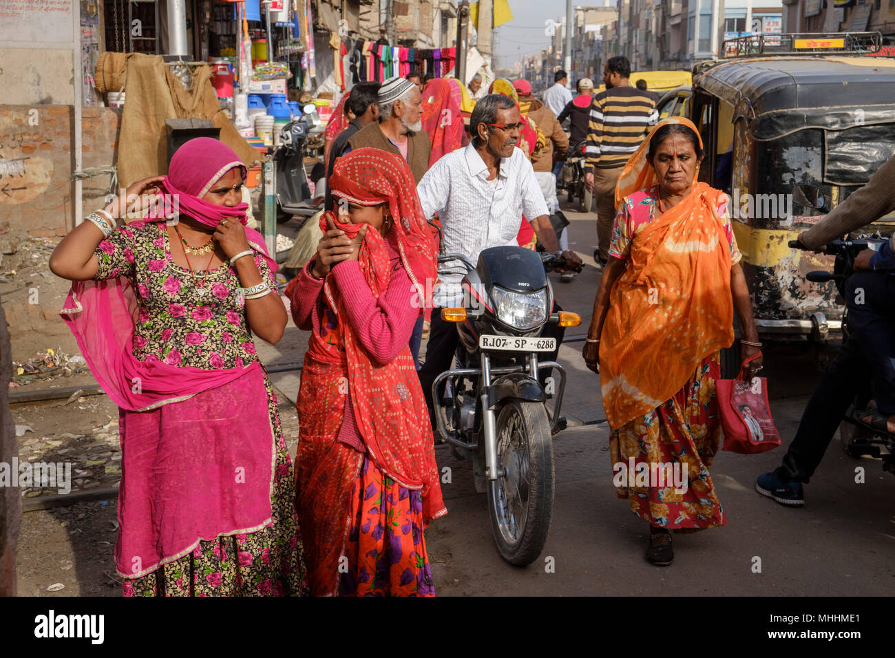 Girls covering their mouths with their headscarfs. Bikaner, Rajasthan. India Stock Photo