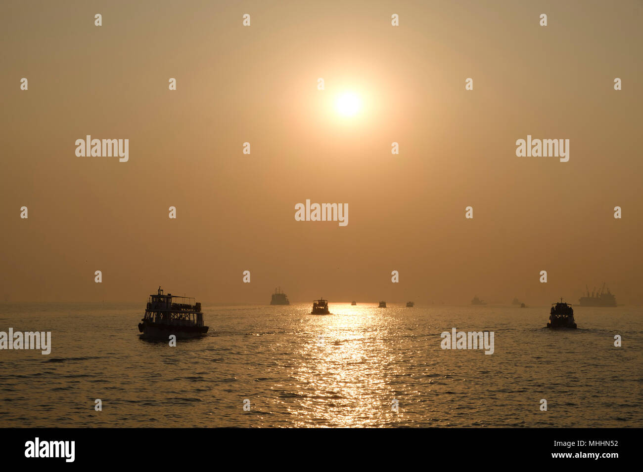 India - Mumbai. Ships in Mumbai harbour at sunset. Stock Photo