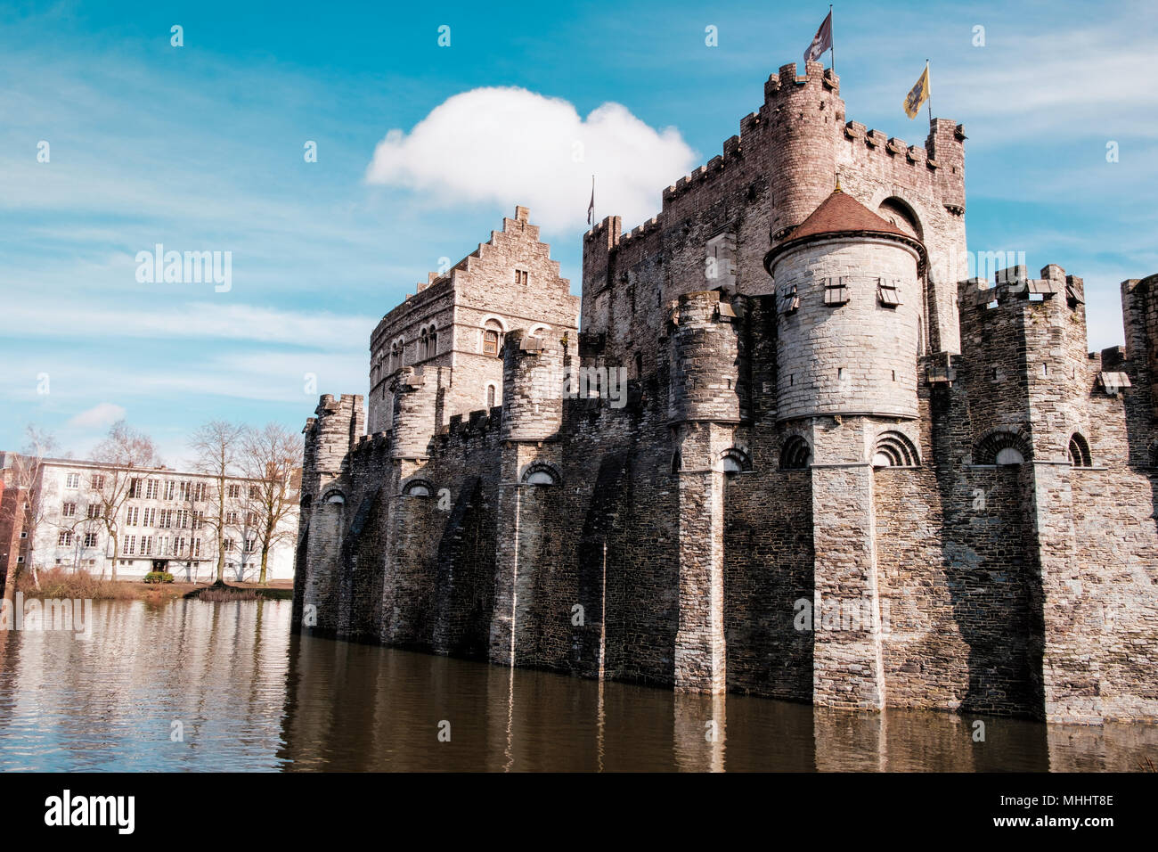The Castle of the Counts, built in 1180 by count Philip of Alsace, surrounded by water in the city center of Ghent on a sunny day under a blue sky. Stock Photo