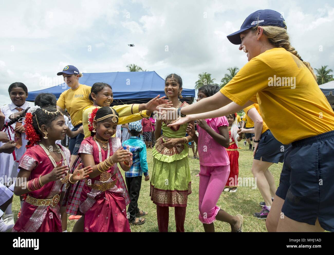 180428-N-MD713-0028 TRINCOMOLEE, Sri Lanka (April 28, 2018) Sailors assigned to Military Sealift Command hospital ship USNS Mercy (T-AH 19) dance with students from T/mu/Paddithidal Maha Vidyalayam School during a U.S. Pacific Fleet Band performance in support of Pacific Partnership 2018 (PP18), April 28, 2018. PP18's mission is to work collectively with host and partner nations to enhance regional interoperability and disaster response capabilities, increase stability and security in the region, and foster new and enduring friendships across the Indo-Pacific Region. Pacific Partnership, now i Stock Photo