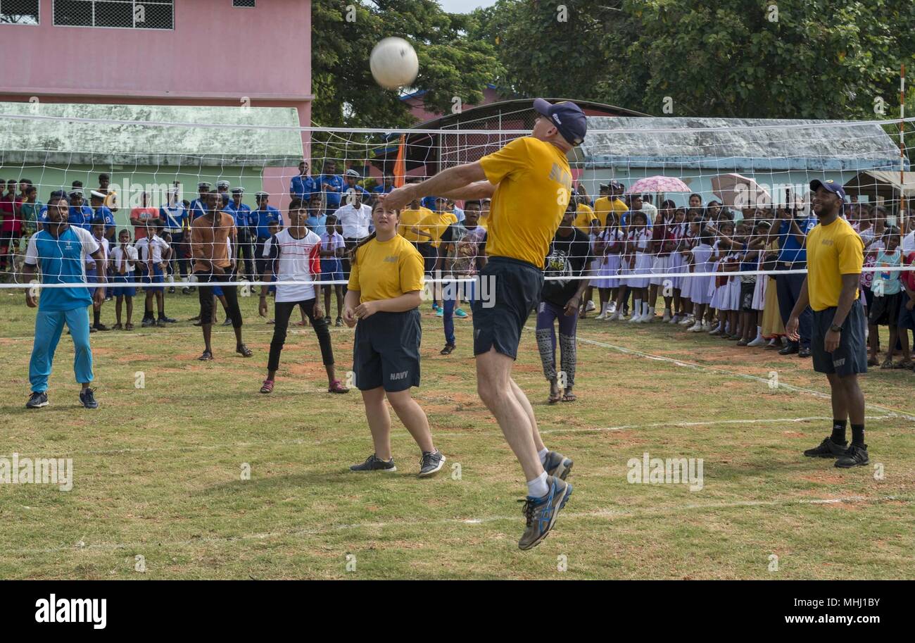 180428-N-MD713-0154 TRINCOMOLEE, Sri Lanka (April 28, 2018) Sailors assigned to Military Sealift Command hospital ship USNS Mercy (T-AH 19) participate in a volleyball game with students and staff from T/mu/Paddithidal Maha Vidyalayam School during a U.S. Pacific Fleet Band performance as a part of Mercy's community relations event in support of Pacific Partnership 2018 (PP18), April 28, 2018. PP18's mission is to work collectively with host and partner nations to enhance regional interoperability and disaster response capabilities, increase stability and security in the region, and foster new Stock Photo