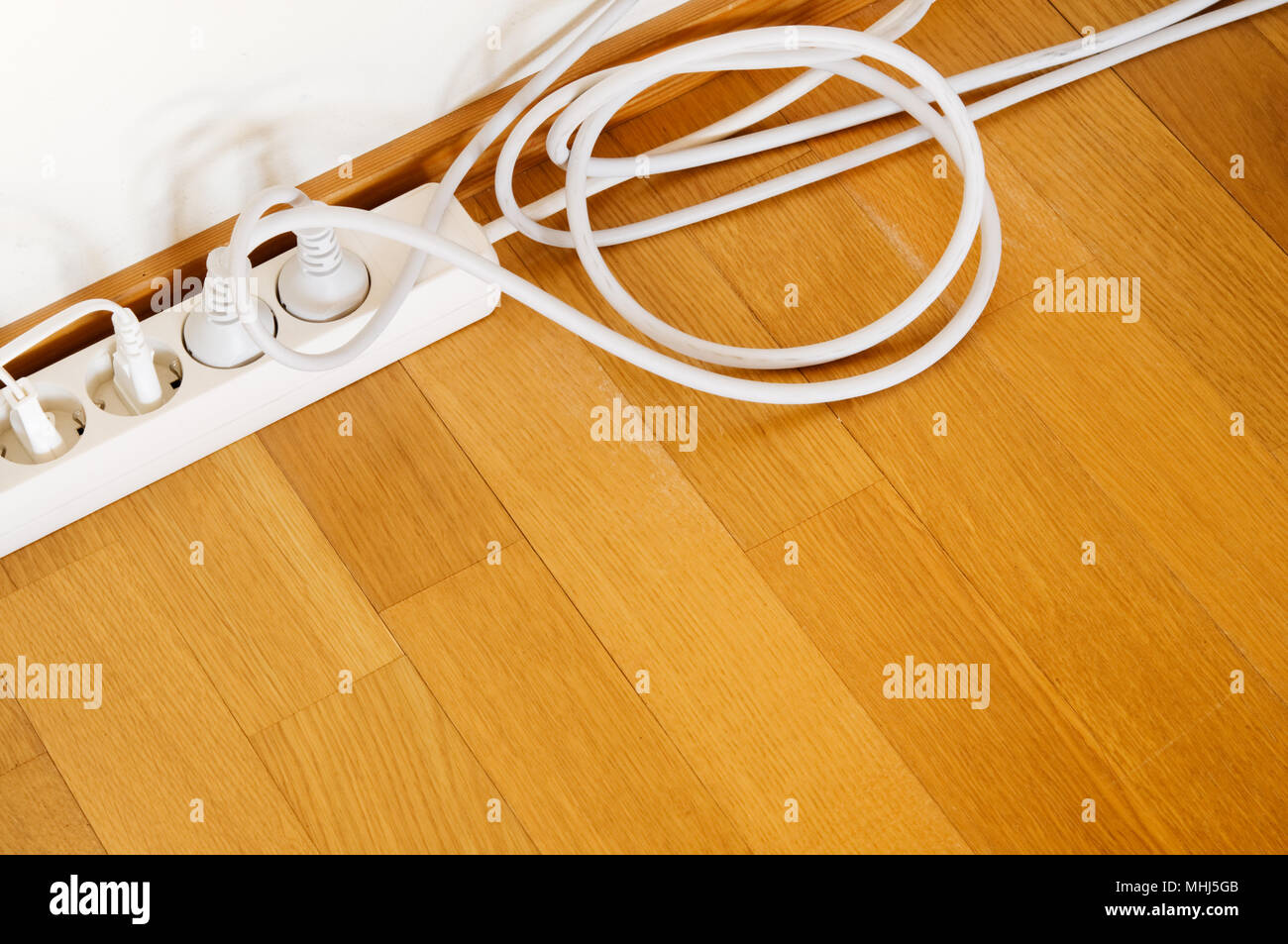 Multiple socket and plugs on wooden floor Stock Photo Alamy