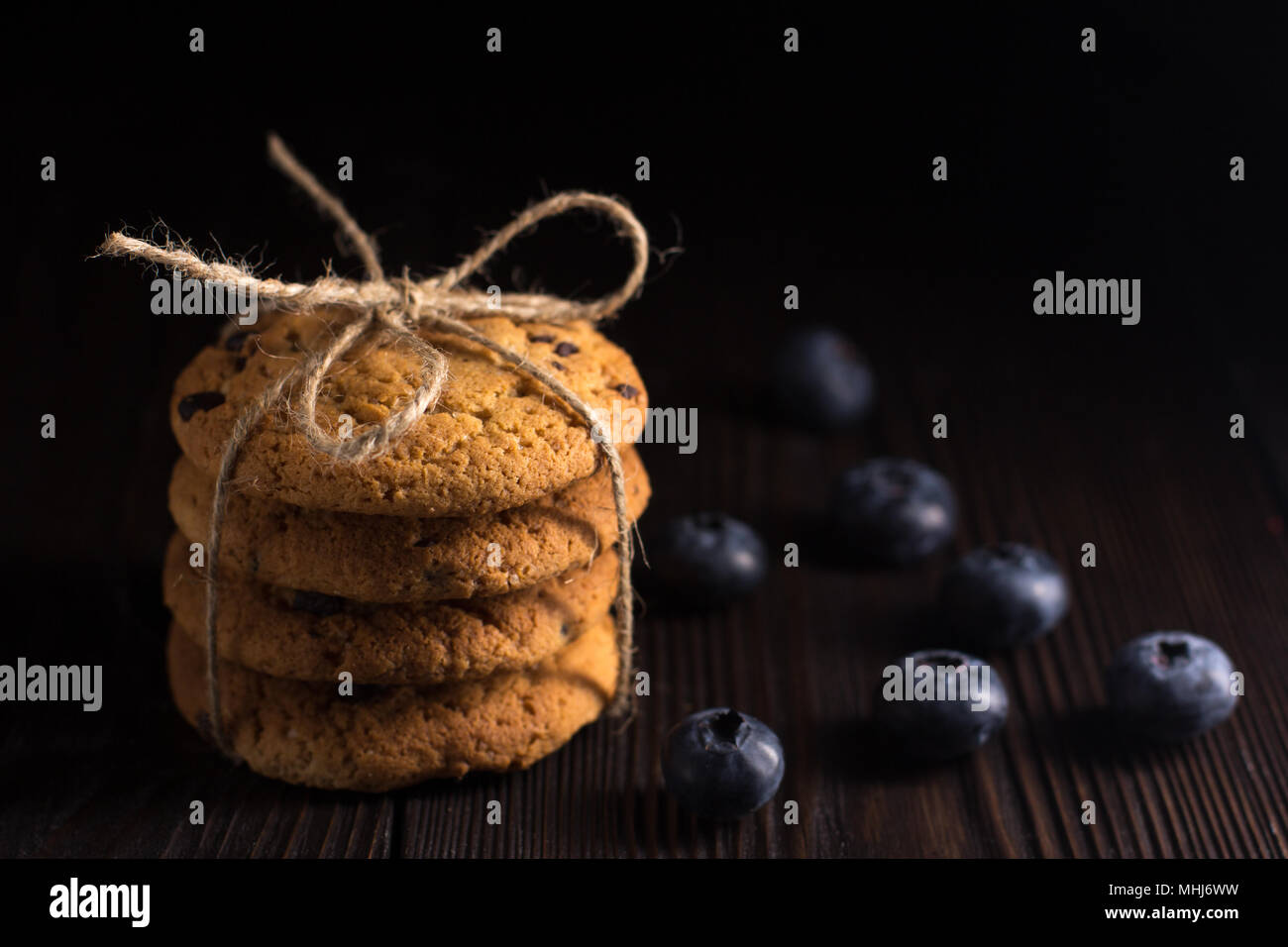 Oatmeal cookies with fresh blueberry on wooden low key background Stock Photo