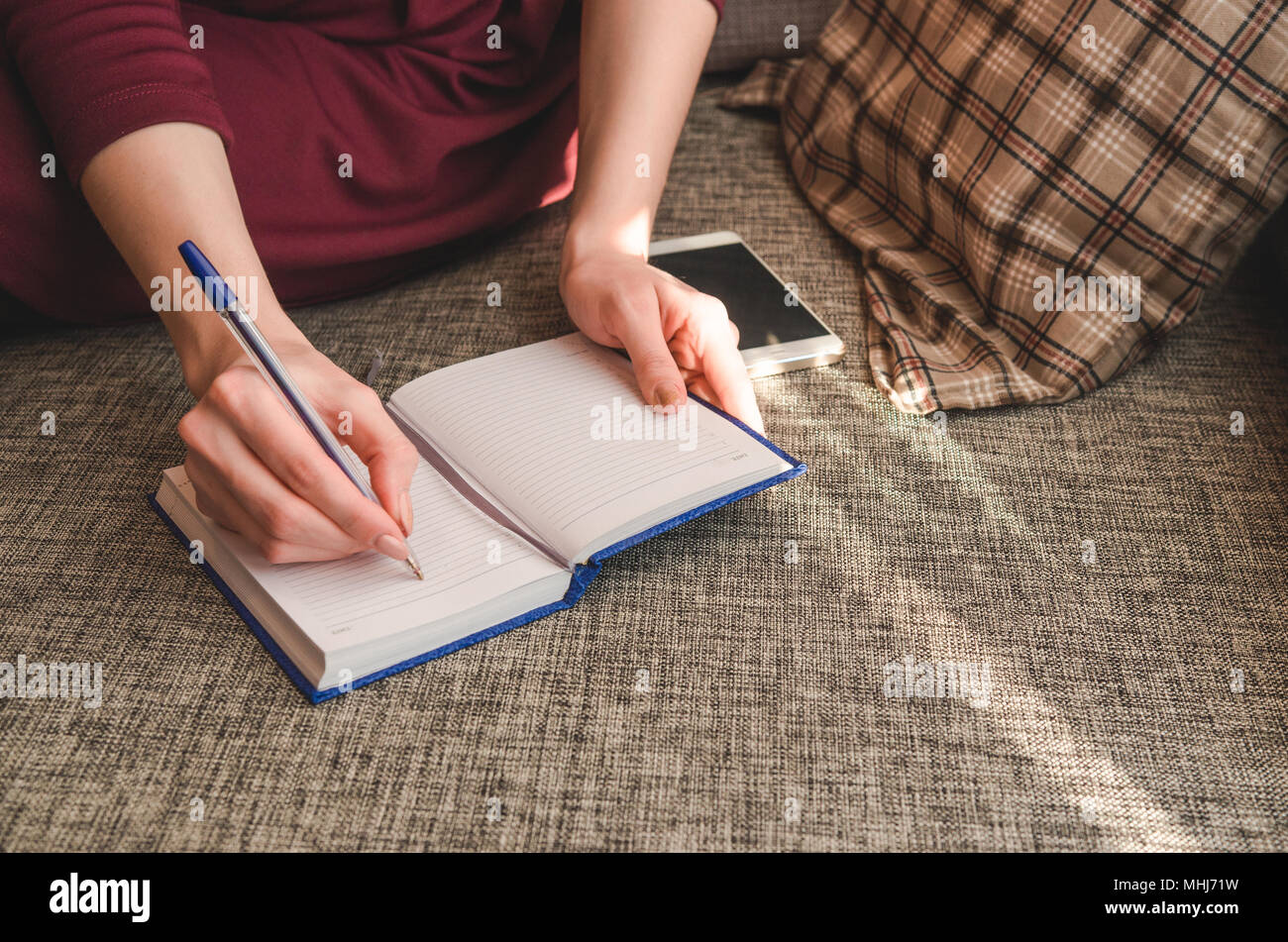 Close up hands woman writing in her notebook Stock Photo