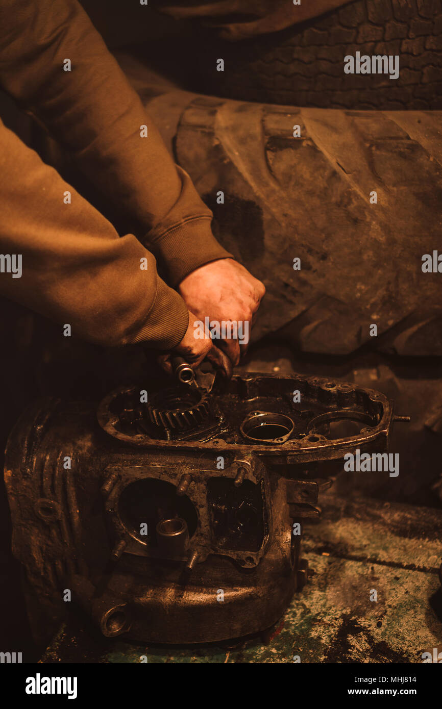 Motorcycle engine disassembly. Man removes rusty detail. Removal of