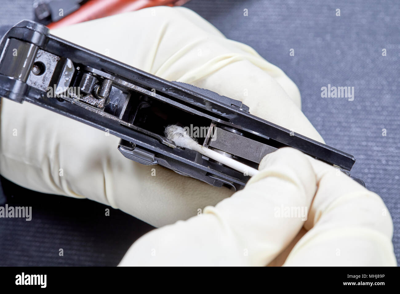 Gloved hands using a cotton swab to clean the inside of a 22 gun chamber Stock Photo Alamy