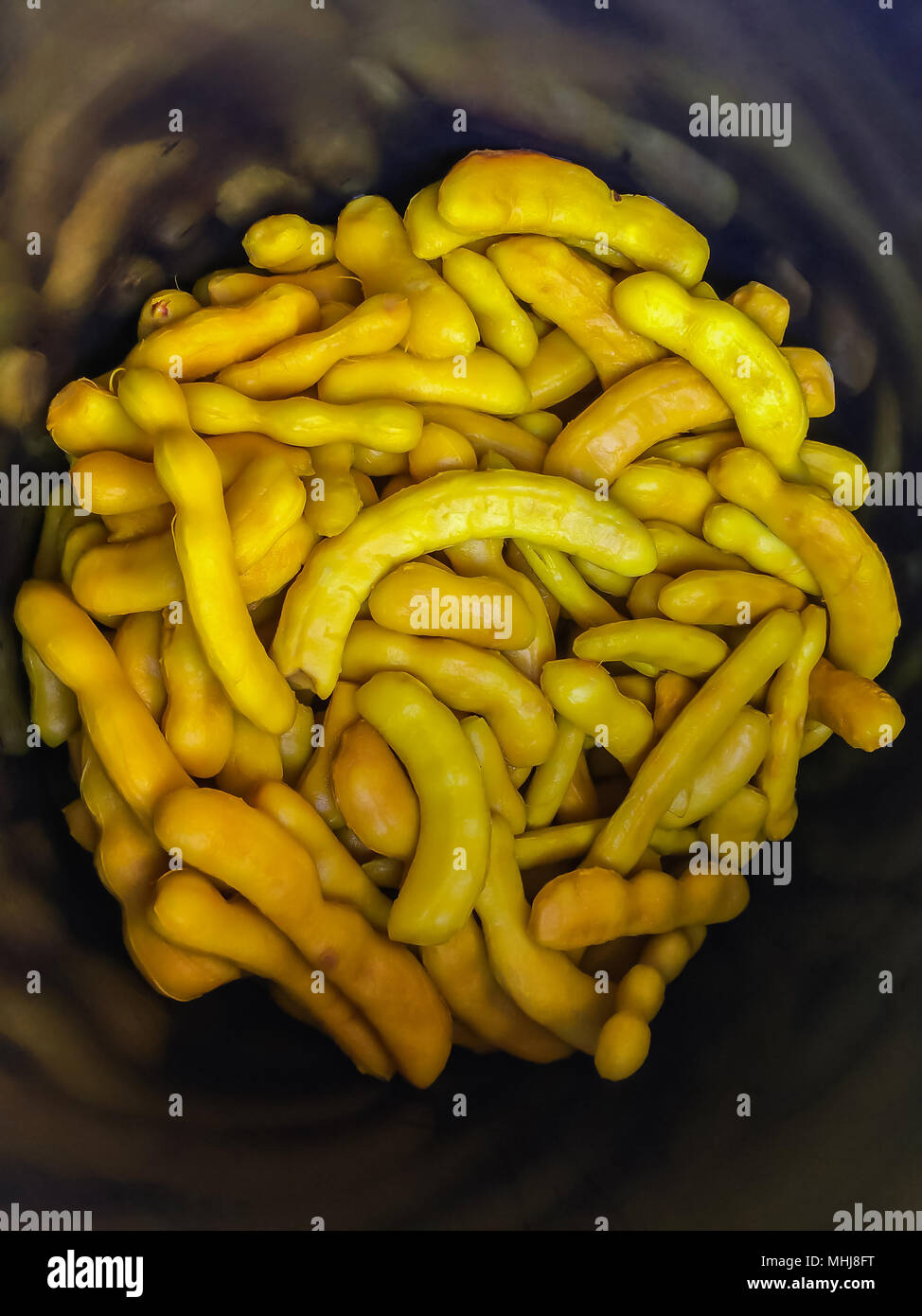 Pickled tamarind fruit preserved in syrup in a market in Thailand. Stock Photo