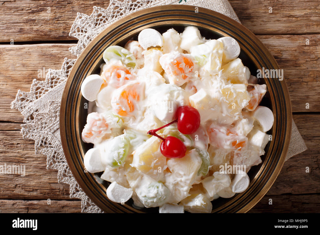 Light fruit salad Ambrosia with marshmallow and vanilla yogurt close-up on a plate. horizontal top view from above Stock Photo