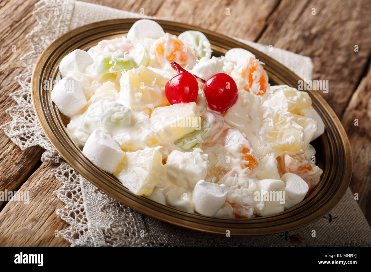 Organic healthy fruit salad Ambrosia with marshmallow and vanilla yogurt close-up on a plate. horizontal Stock Photo