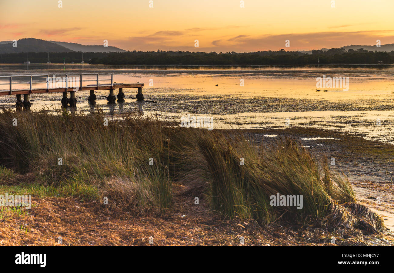 Dawn Waterscape with Wharf - Capturing the sunrise from Woy Woy Waterfront on the Central Coast, NSW, Australia. Stock Photo