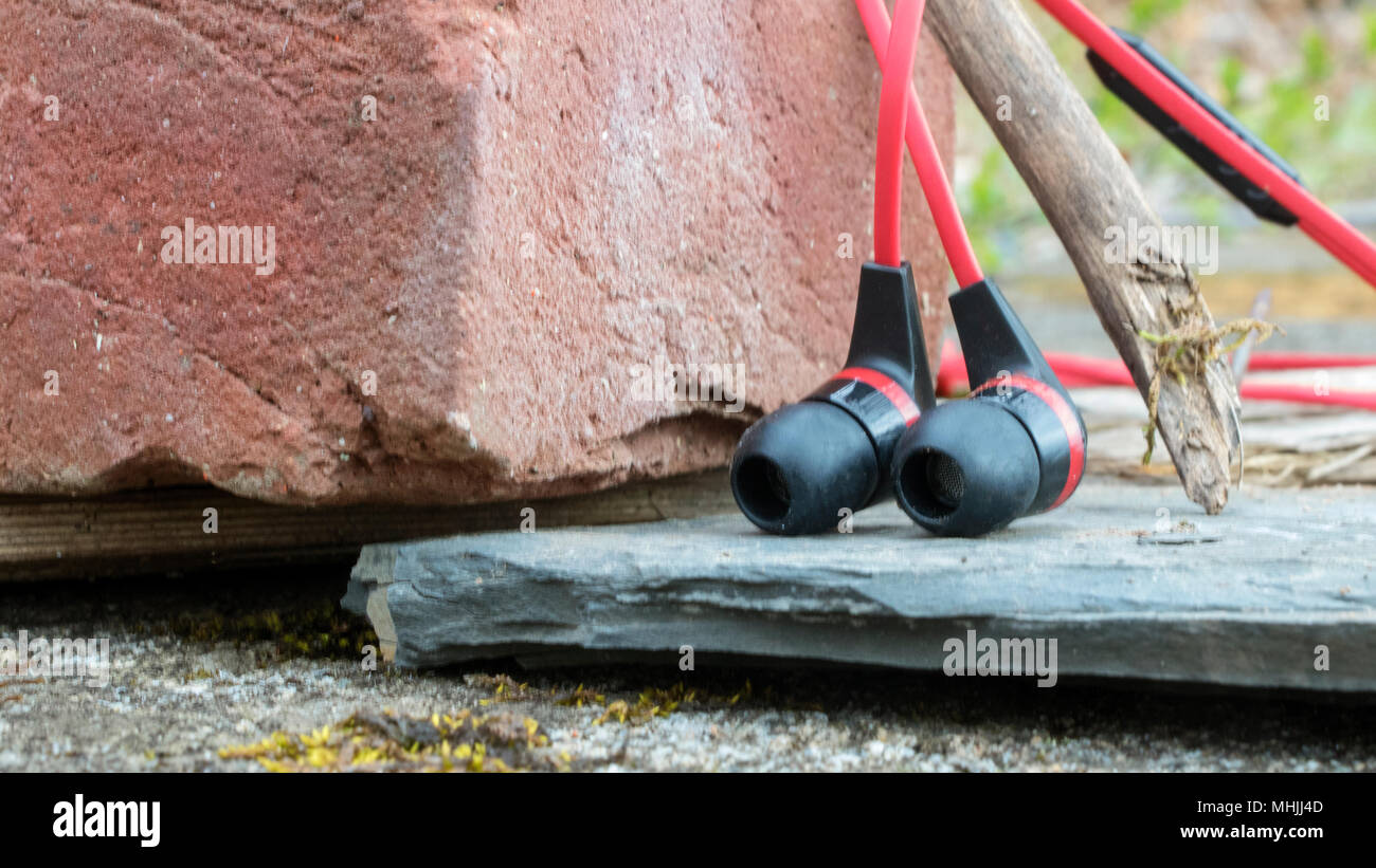 Earbuds lay in the forest combining nature and technology Stock Photo -  Alamy