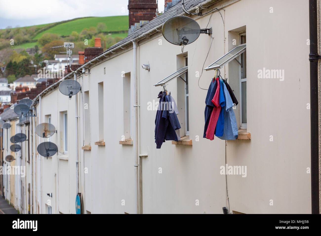Shirts hanging from first floor window of terraced house to dry Stock Photo