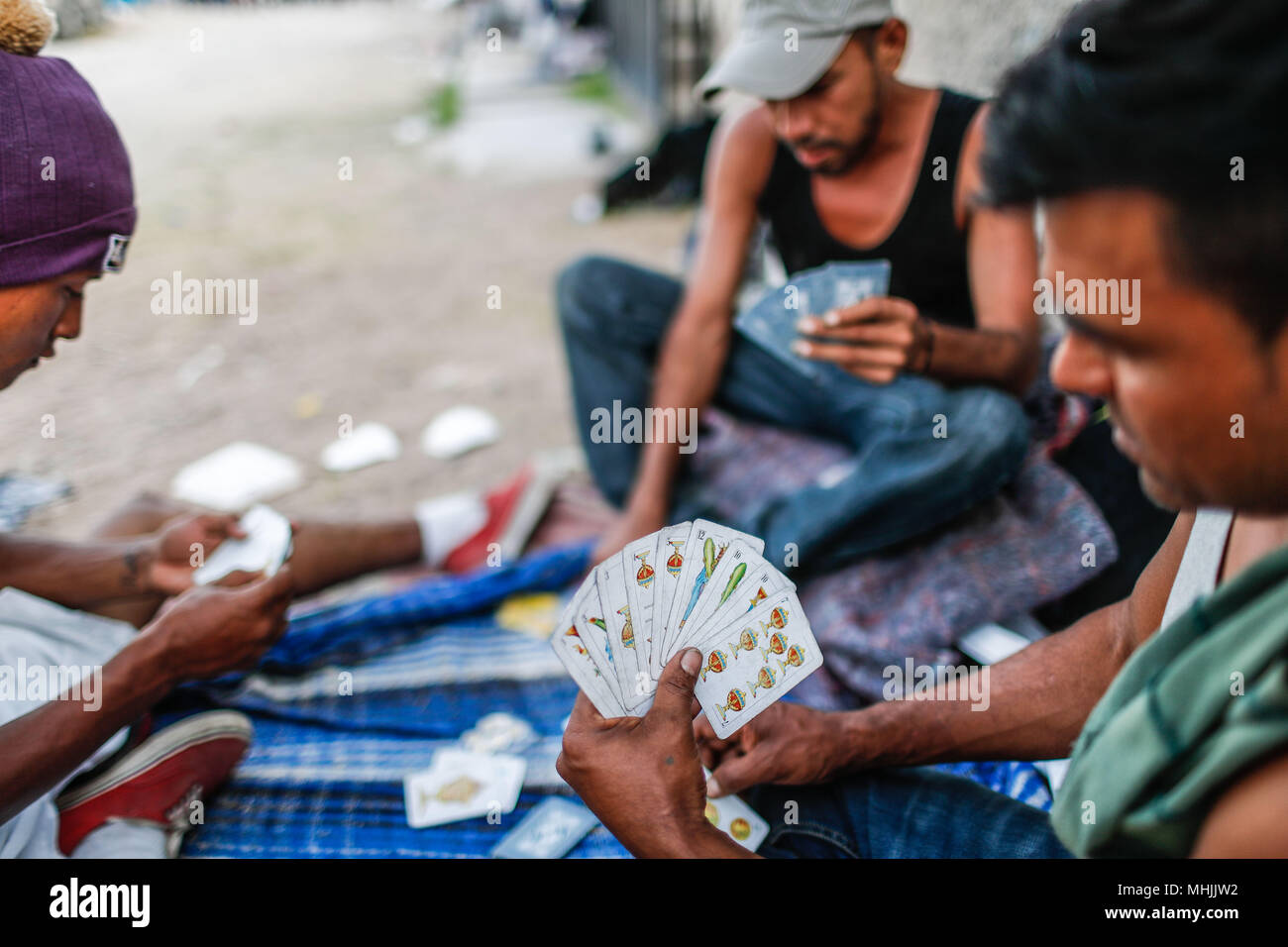Algunos migrantes pasan el tiempo jugando a las cartas. Barajas, apuesta.  Donald Trump, presidente de los Estados Unidos, continua con su plan este l Stock Photo