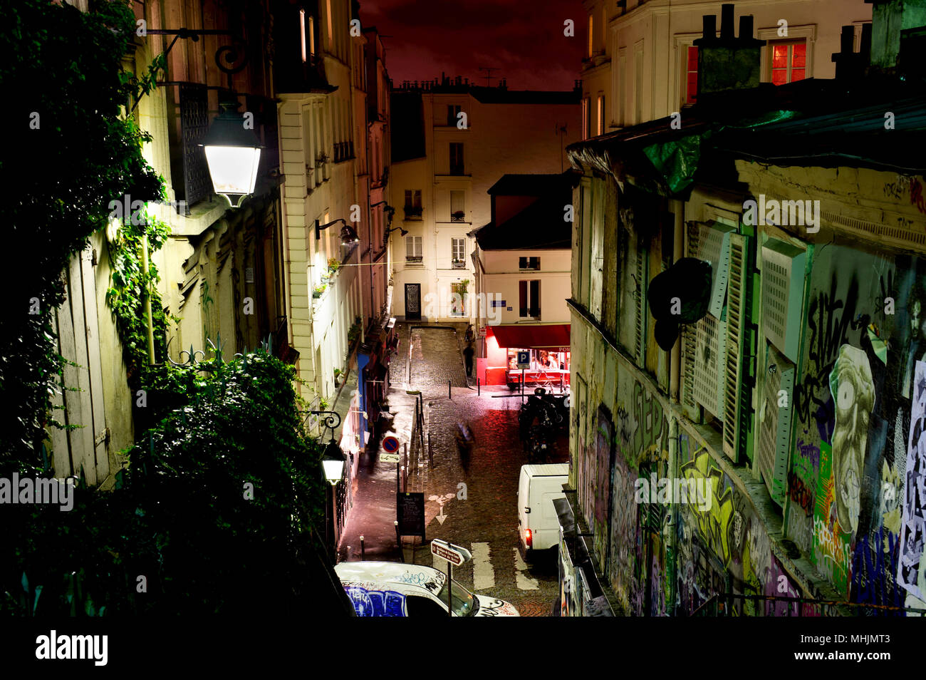 PARIS, FRANCE - 12th of OCTOBER 2012: Street of historical buildings and modern art graffiti on Montmartre by night. October 12th, 2012. Paris, France Stock Photo