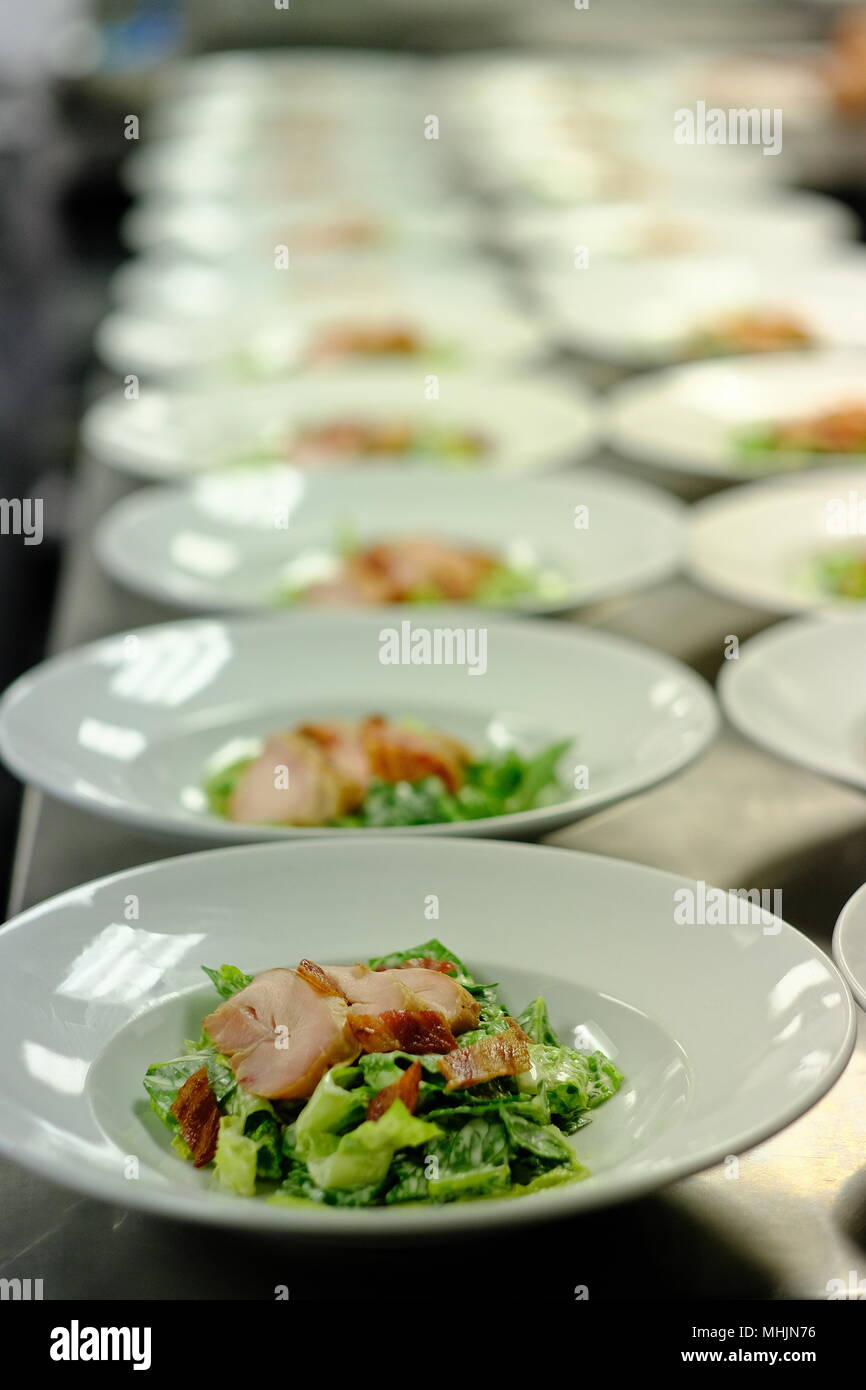 student preparing meals for their graduation guests at a cooking school Stock Photo