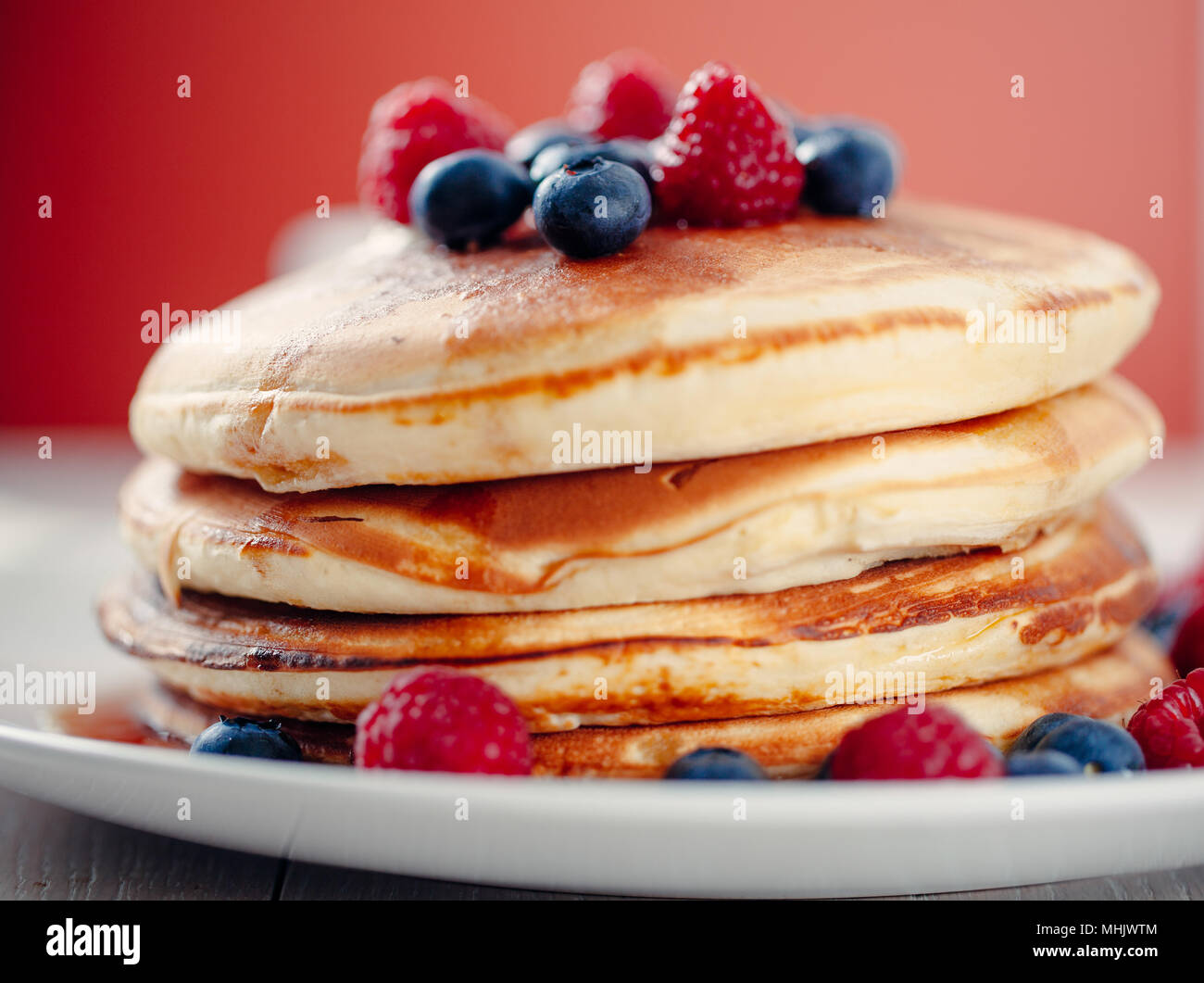 Pancakes with berries and maple syrup Stock Photo