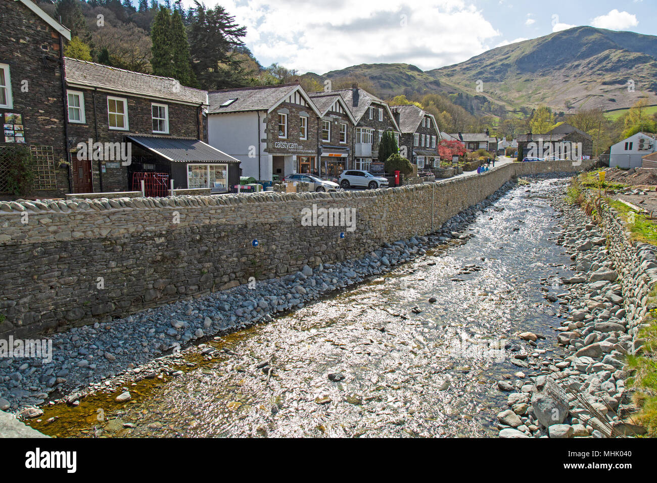 The village of Glenridding on the southern shores of Ullswater in the Lake District National Park in England, with the river, Glenridding Beck Stock Photo