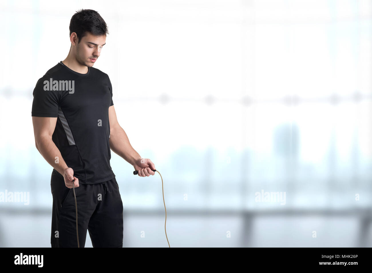 Fit athlete jumping rope, in a gym Stock Photo