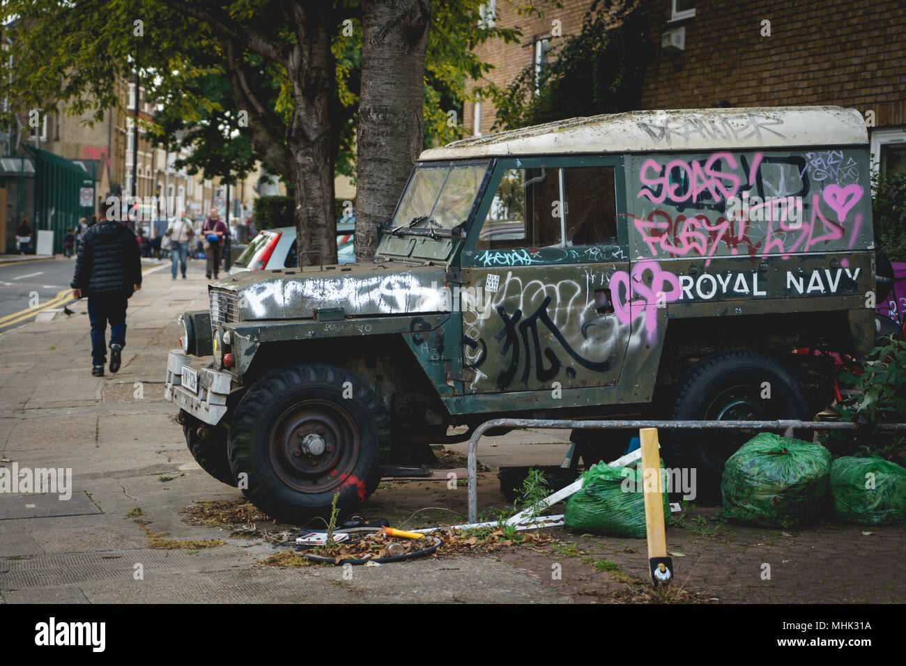 London, UK - March, 2018. Abandoned old army off-road vehicle covered with graffiti in Shoreditch. Landscape format. Stock Photo