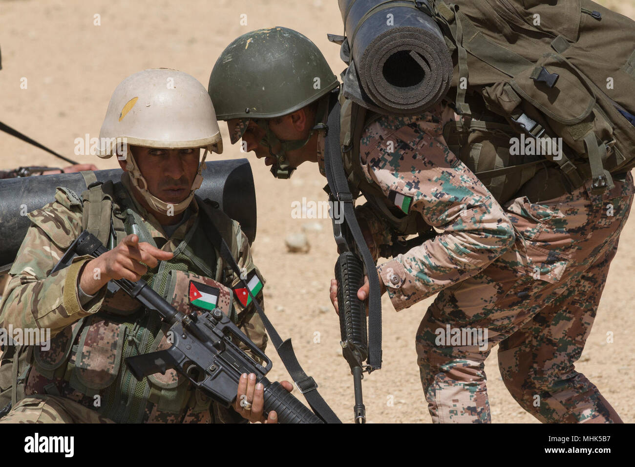 An assistant squad leader reports to his squad leader during a simulated  patrol as part of the culminating exercise of the Jordan Armed Forces  Noncommissioned Officer Academy Squad Leader Course, March 21,