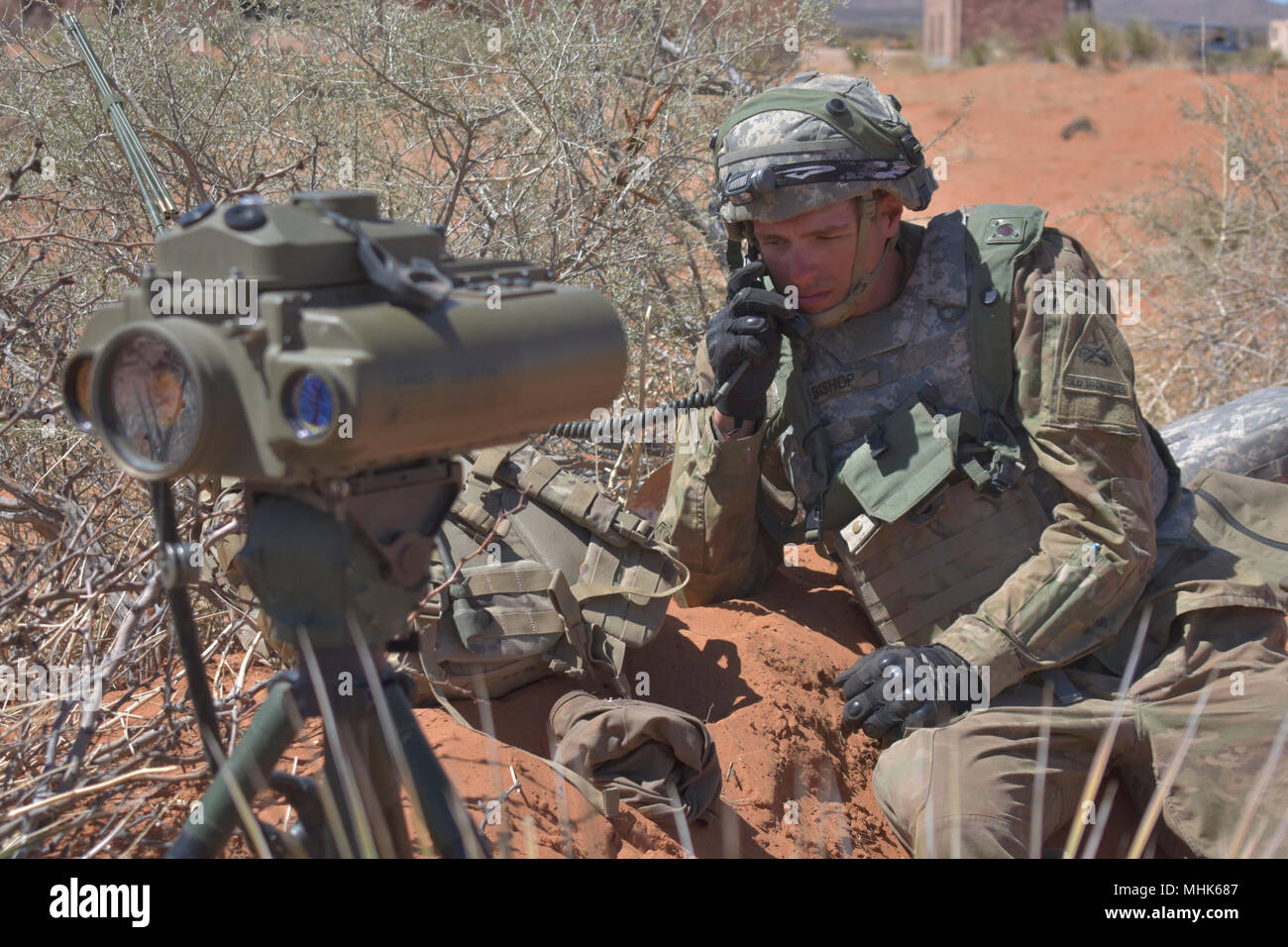Pfc. Kaleb Bishop, a fire support specialist with 2nd Battery, 3rd Field Artillery Regiment, 1st Armored Division Artillery, communicates a situation report after scanning his sector with a Lightweight Laser Designator Rangefinder at the Combined Arms Collective Training Facility, Orogrande, N.M., March 22, 2018. Bishop’s unit took the role of opposing force in Iron Focus 18.1, a major training event in which various units of Fort Bliss took part of. (U.S. Army Stock Photo