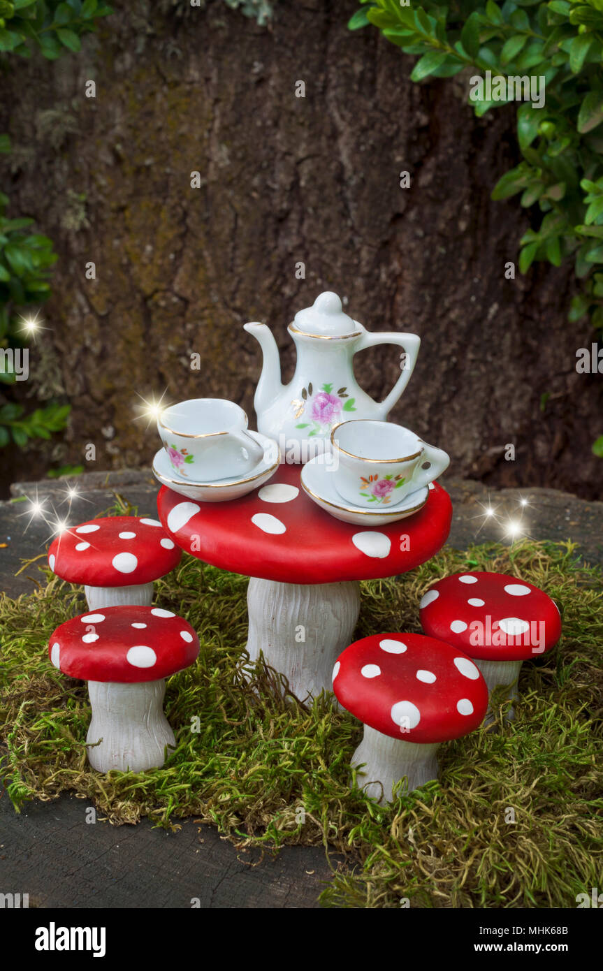 Tea party with fairies in forest with sparks of light Stock Photo