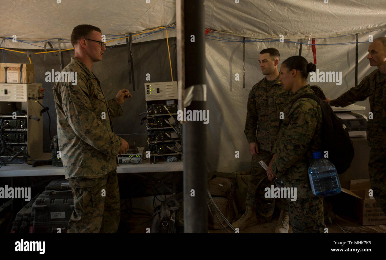 U.S. Marine students with the Aviation Ground Support class discuss communications with Cpl. Nathan Chambliss, a Marine Wing Support Squadron 272 field radio operator, during a static tour and capabilities brief in support of Weapons and Tactics Instructor course 2-18 at Site-50 Wellton, Ariz., March 23. WTI is a seven-week training event hosted by MAWTS-1 cadre, which emphasizes operational integration of the six functions of Marine Corps aviation in support of a Marine Air Ground Task Force and provides standardized advanced tactical training and certification of unit instructor qualificatio Stock Photo