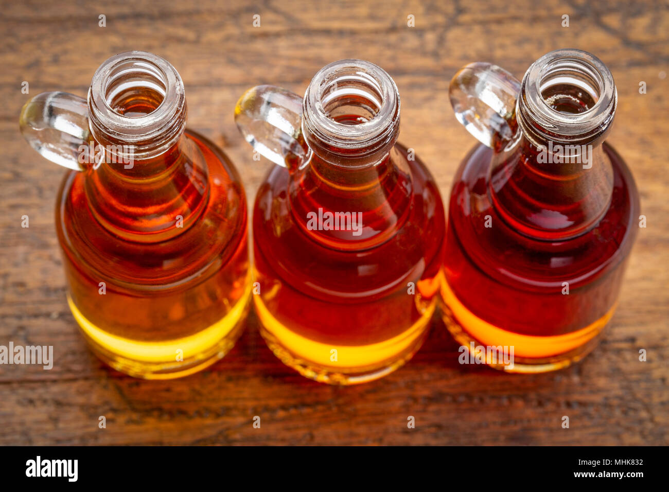 sampler of pure maple syrup (golden, amber and gold) small glass bottles against rustic wood