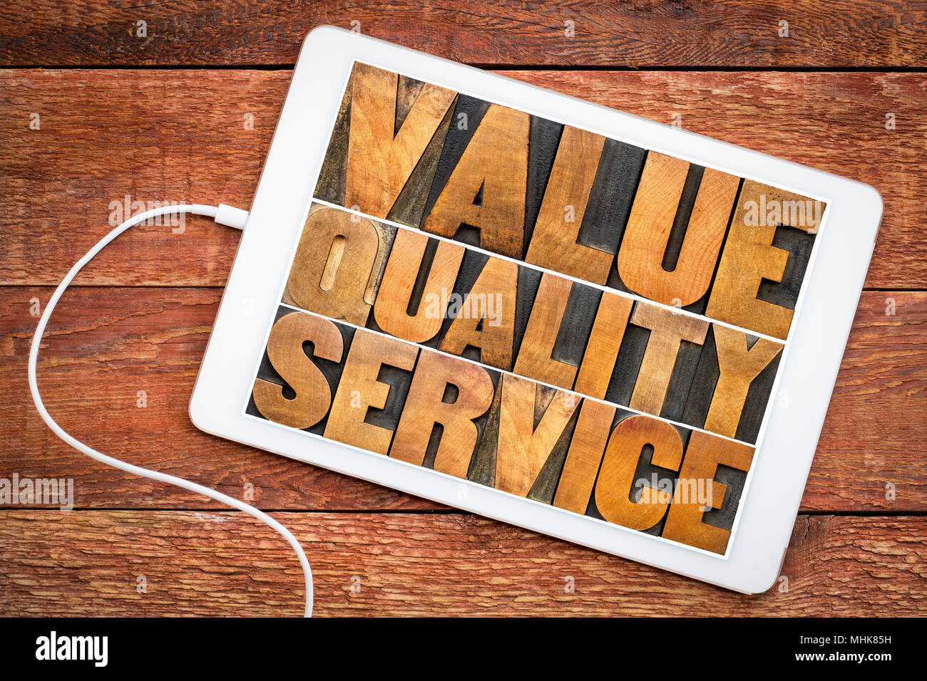 value, quality, service - business mantra or motto concept - word abstract in vintage letterpress wood type printing blocks on a digital tablet Stock Photo