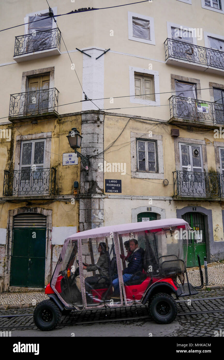 Tuk-Tuk drives in Alfama district streets, Alfama, Lisbon, Portugal Stock Photo