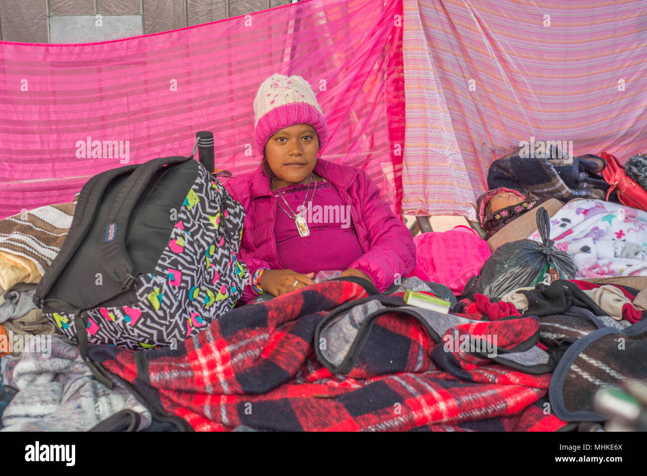 Tijuana, Mexico. 1st May, 2018. Members of the migrant caravan from Central America camp out under donated tarp and in tents at the Mexico-US Border El Chaparral crossing. They are seeking asylum in the United States and will have to wait in Mexico until process is complete. Young migrant traveled from El Salvador to seek asylum in United States. Credit: Vito Di Stefano/ZUMA Wire/Alamy Live News Stock Photo