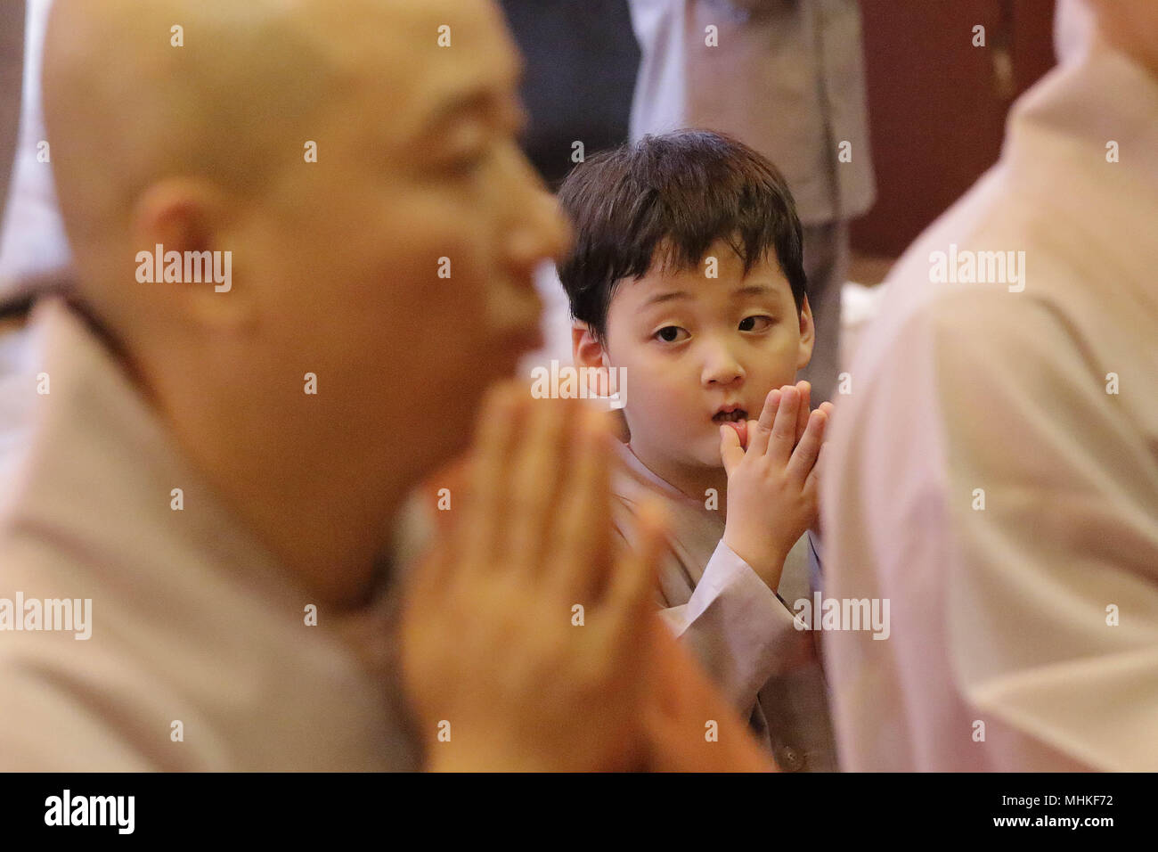 May 2, 2018 - Seoul, SOUTH KOREA - May 2, 2018-Seoul, South Korea-A child gets his head shaved by a Buddhist monk during the 'Children Becoming Buddhist Monks' ceremony forthcoming buddha's birthday at a Chogye temple in Seoul, South Korea. Children have their hair shaved off during the 'Children Becoming Buddhist Monks' ceremony ahead of buddha's birthday at a Chogye temple. The children will stay at the temple to learn about Buddhism for 20 days. Buddha was born approximately 2,562 years ago, and although the exact date is unknown, Buddha's official birthday is celebrated on the full moon in Stock Photo