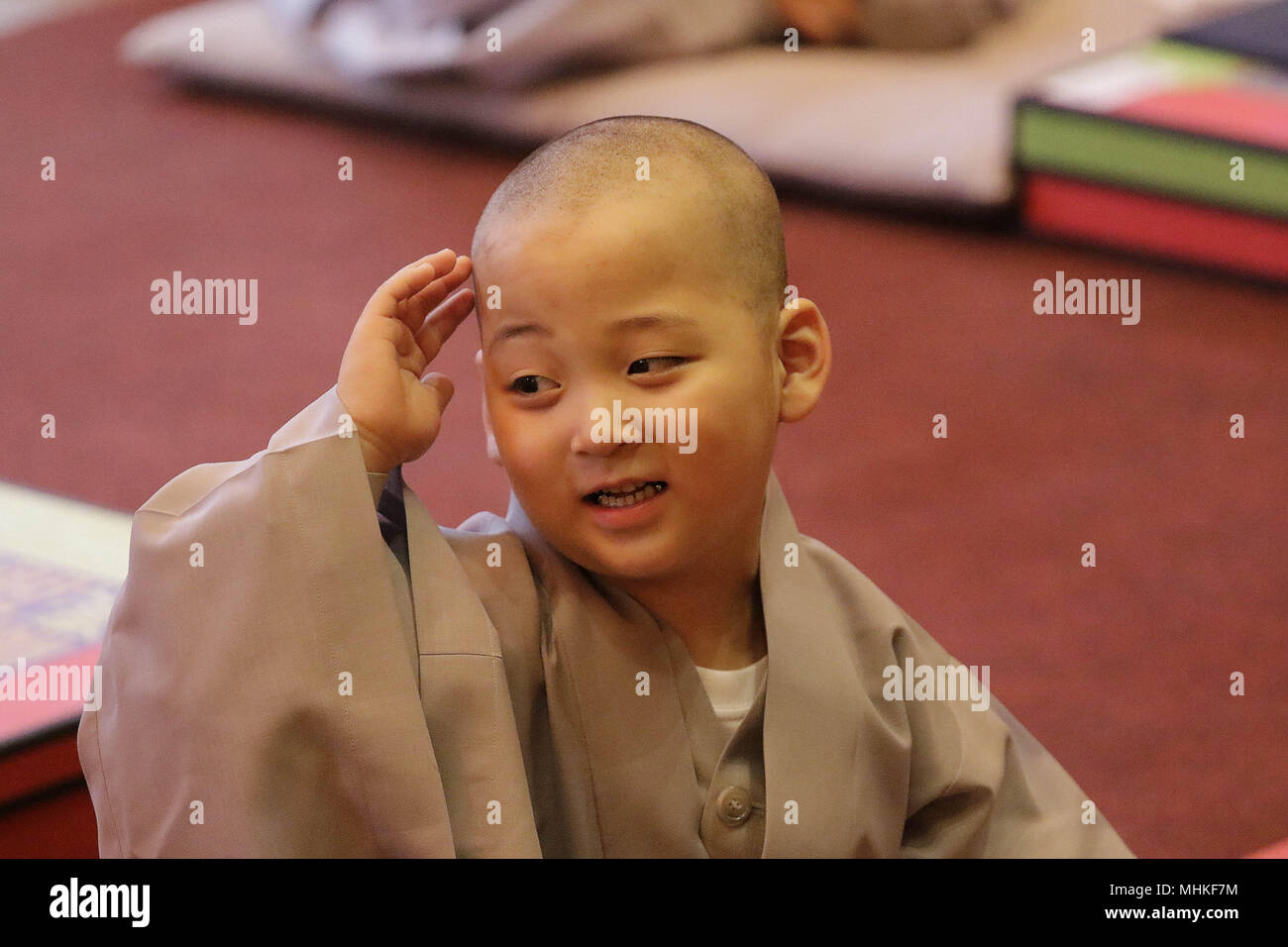 May 2, 2018 - Seoul, SOUTH KOREA - May 2, 2018-Seoul, South Korea-A child gets his head shaved by a Buddhist monk during the 'Children Becoming Buddhist Monks' ceremony forthcoming buddha's birthday at a Chogye temple in Seoul, South Korea. Children have their hair shaved off during the 'Children Becoming Buddhist Monks' ceremony ahead of buddha's birthday at a Chogye temple. The children will stay at the temple to learn about Buddhism for 20 days. Buddha was born approximately 2,562 years ago, and although the exact date is unknown, Buddha's official birthday is celebrated on the full moon in Stock Photo