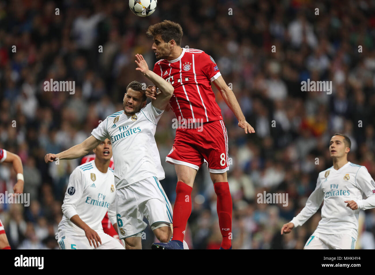 Madrid, Spain. May, JAVI MARTINEZ Bayern Munich heads the ball under pressure from NACHO of Real Madrid during UEFA Champions League, semi final, 2nd leg football match between