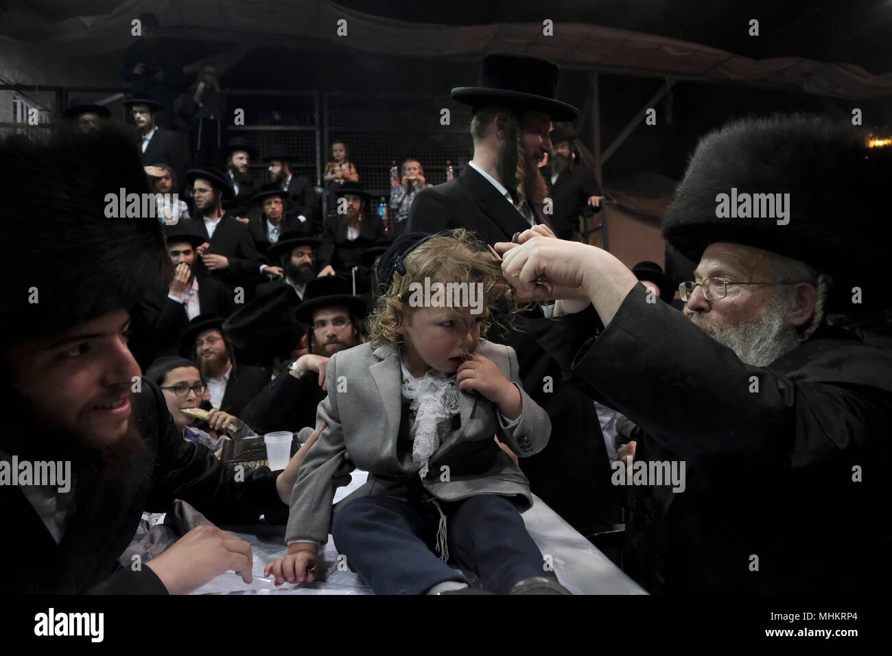 Jerusalem, Israel 02 May 2018. A three-year old Jewish boy takes part in the traditional Halake ceremony, a first hair cut from the Rabbi of the Pinsk-Karlin Hassidic dynasty in Geula religious neighborhood during the celebration of Lag BaOmer holiday which marks the celebration, interpreted by some as anniversary of death of Rabbi Shimon bar Yochai, one of Judaism's great sages some 1800 years ago and the day on which he revealed the deepest secrets of kabbalah a landmark text of Jewish mysticism Credit: Eddie Gerald/Alamy Live News Stock Photo