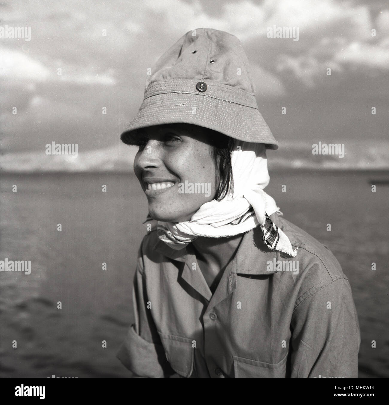 1950s, historical, an attractive Israeli young female conscipt wearing army khaki uniform, scarf and hat, smiles for the camera, Israel. Military conscription in the IDF for all woman aged 18 and over had been mandatory in Israel since 1948. Stock Photo