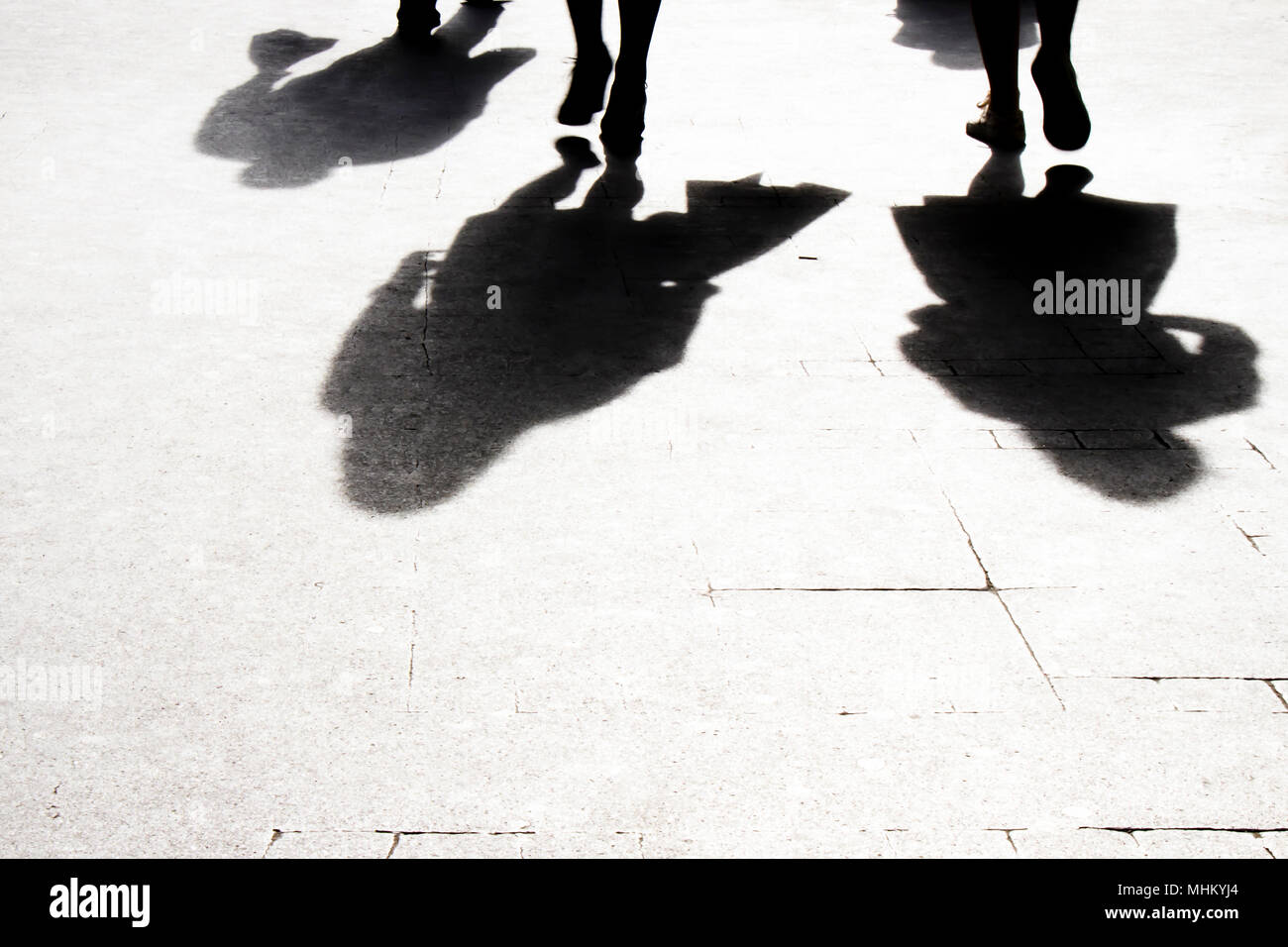 Blurry shadow and silhouette of people walking on the city street  sidewalk , in black and white Stock Photo