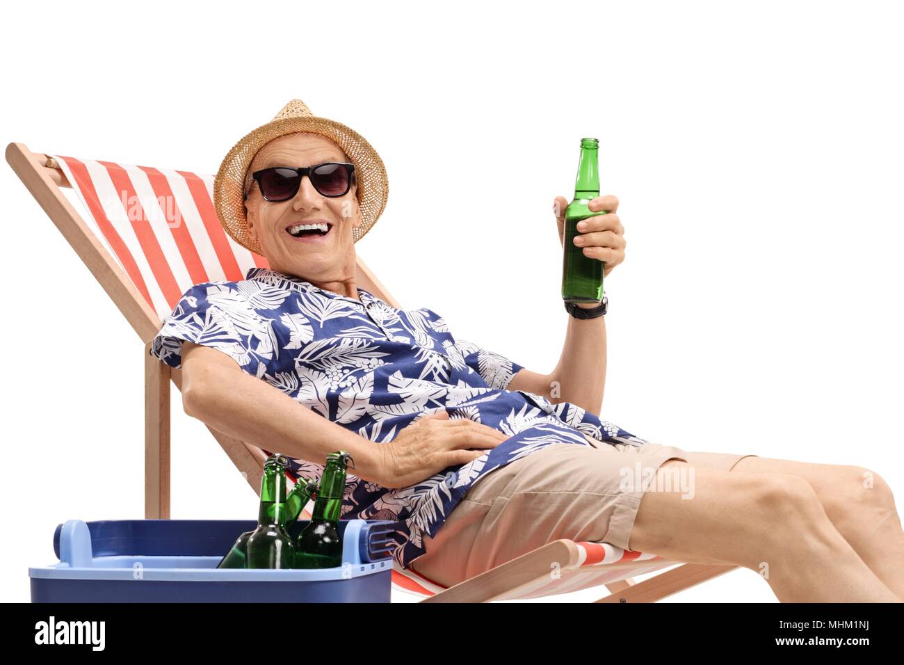 Old tourist seated in a deck chair holding a beer bottle next to a cooling  box isolated on white background Stock Photo - Alamy