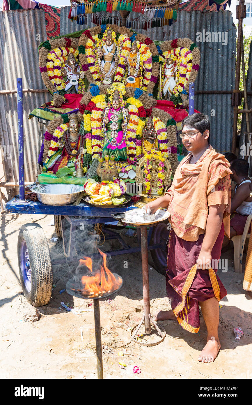 Unidentified brahman man with statues of the Indian gods and offerings ...