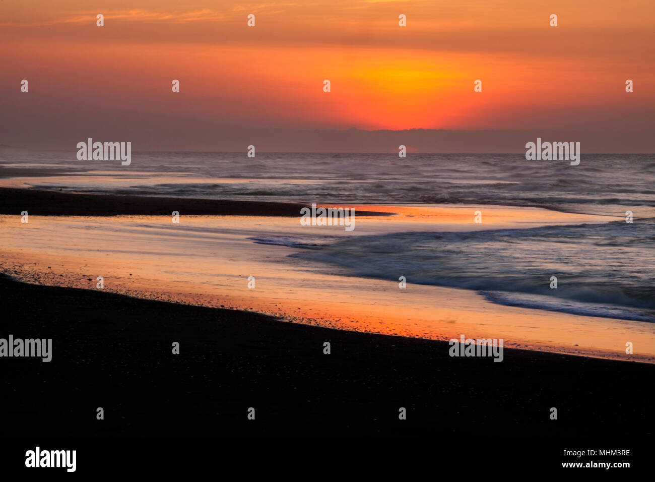 NC01566-00...NORTH CAROLINA - Sunrise over the Atlantic Ocean from the beach on Ocrracoke Island in the Outer Banks, Cape Hatteras National Seashore. Stock Photo