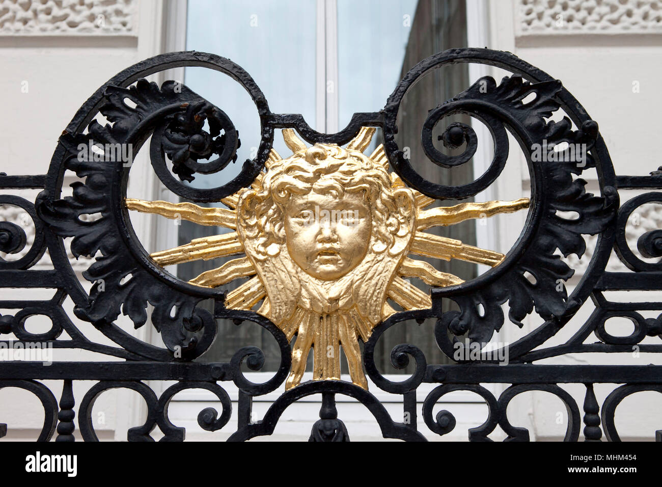 Gold painted sun  on iron black gate gate in Londons west end united kingdom Stock Photo