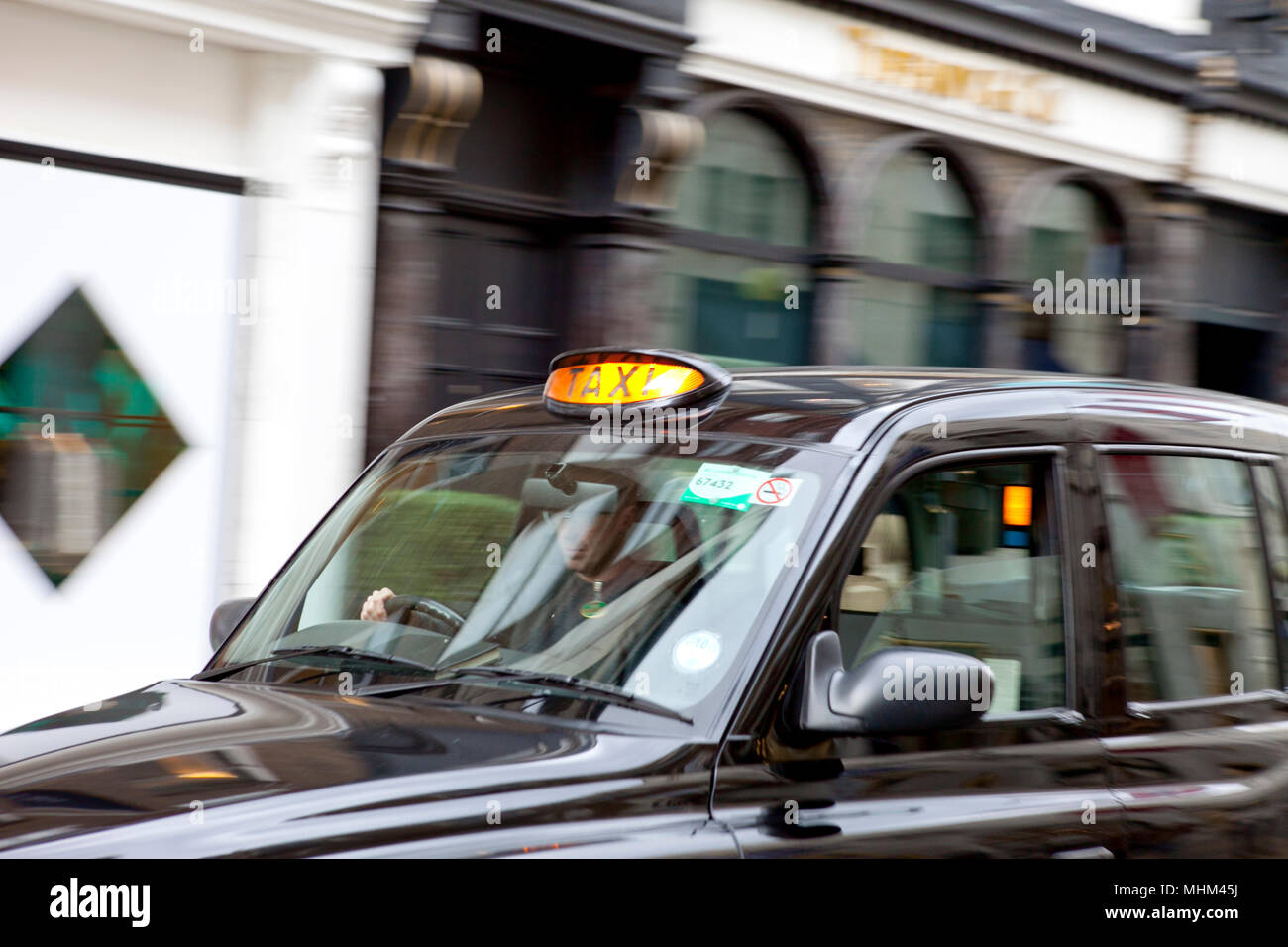 London taxi cab speeding through London with for hire light on Stock Photo