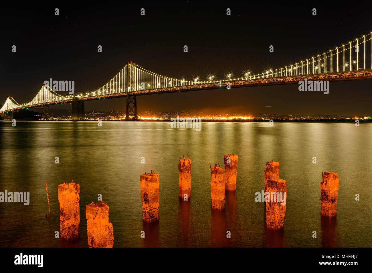 Bay Bridge at Night - A night view of San Francisco – Oakland Bay Bridge spanning over calm San Francisco Bay, California, USA. Stock Photo
