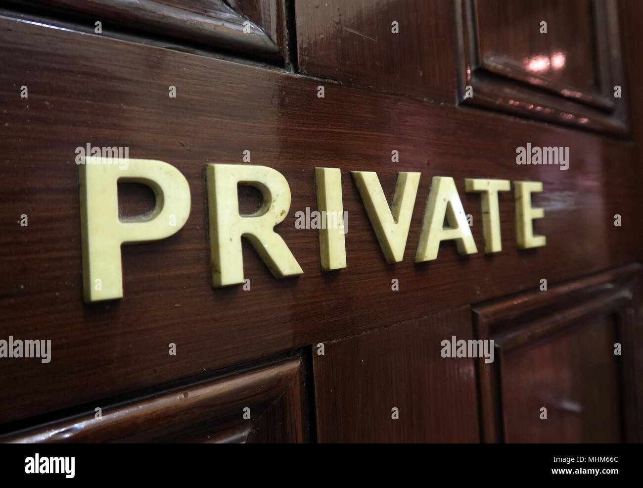 Private in letters, on a brown wooden door - keeping personal and commercial data private Stock Photo